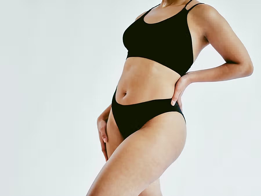 Model in stylish black sportswear on white background.