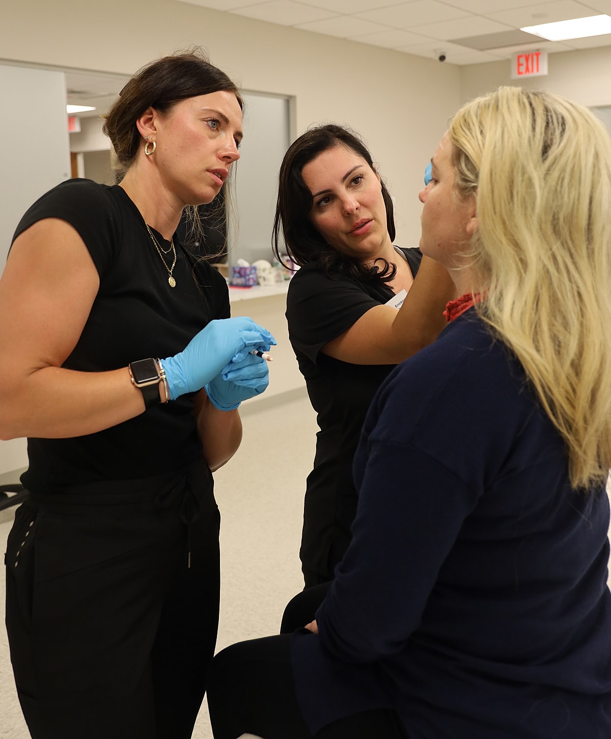 Women applying cosmetic treatment in a clinic.