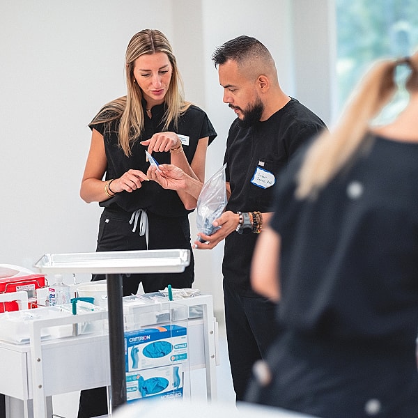 Medical professionals discussing tools in a lab.