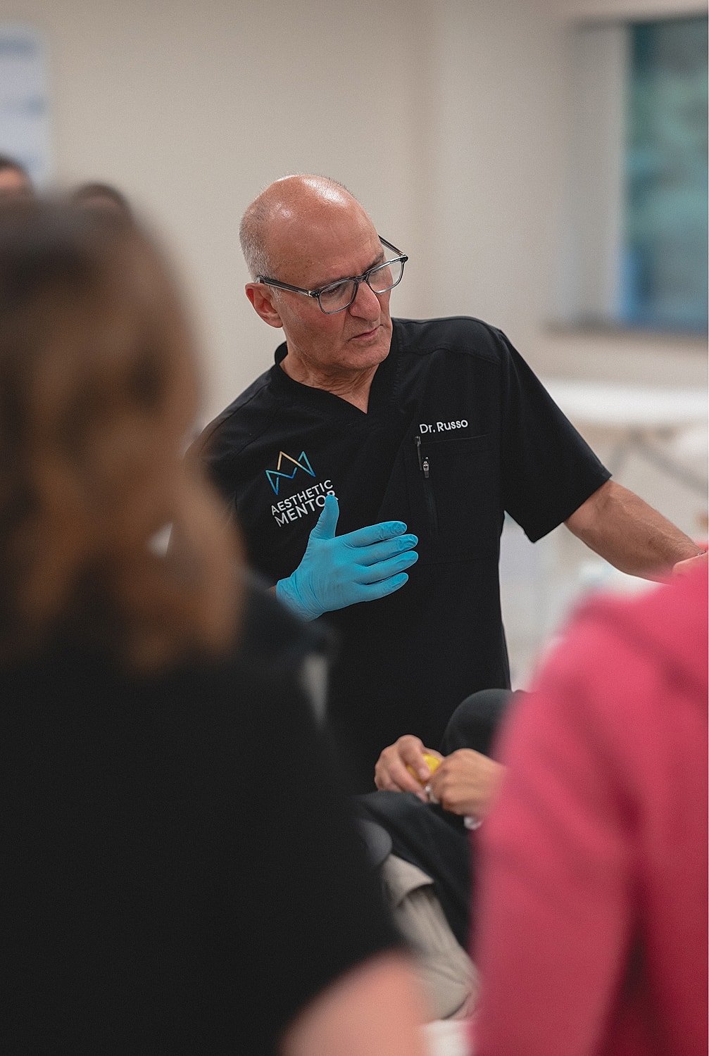 Doctor performing a procedure with attentive audience.