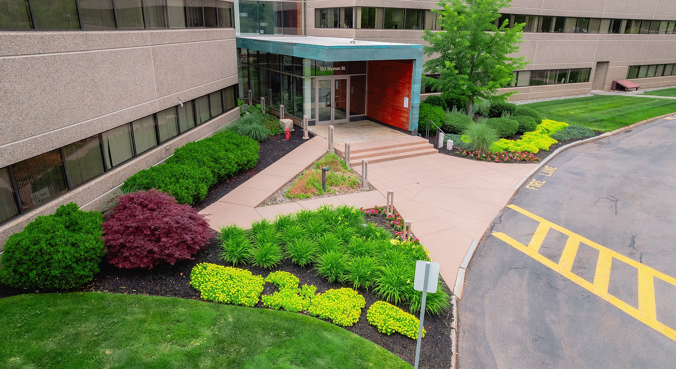 Office entrance with landscaped garden and sidewalks.