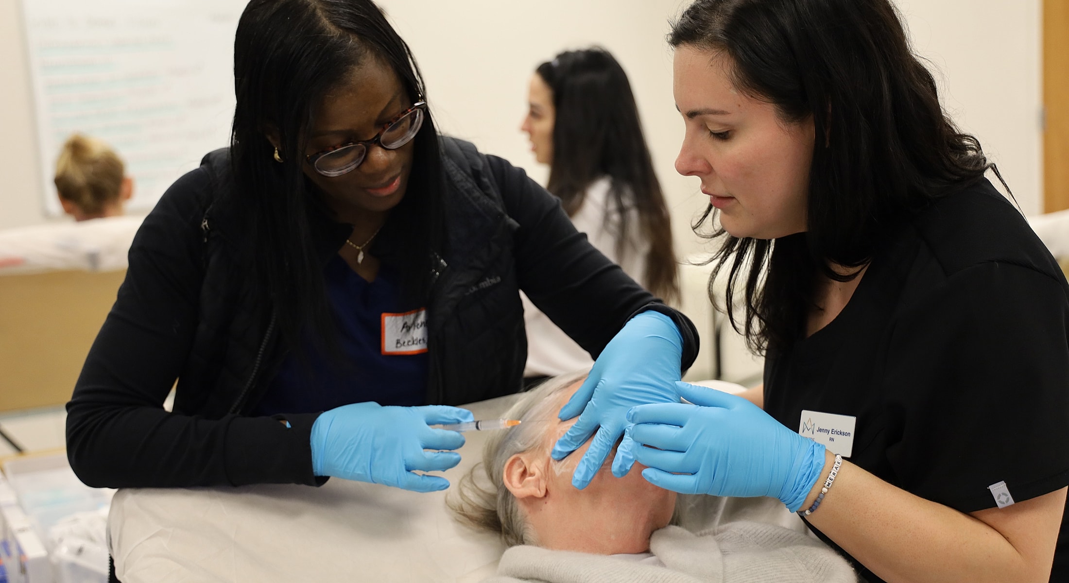 Medical professionals practicing facial procedures on patient.
