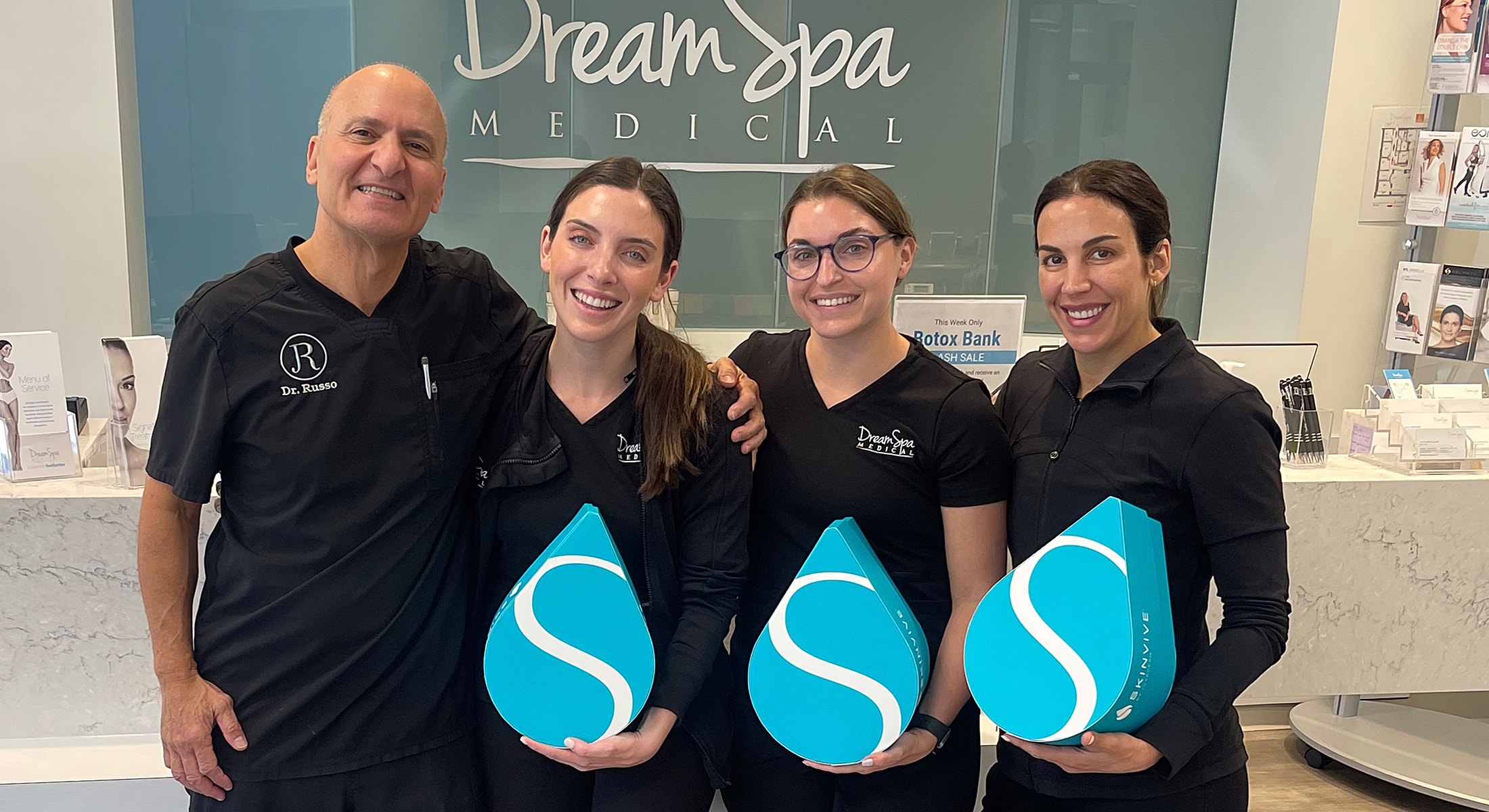 Dream Spa Medical team holding skincare products.