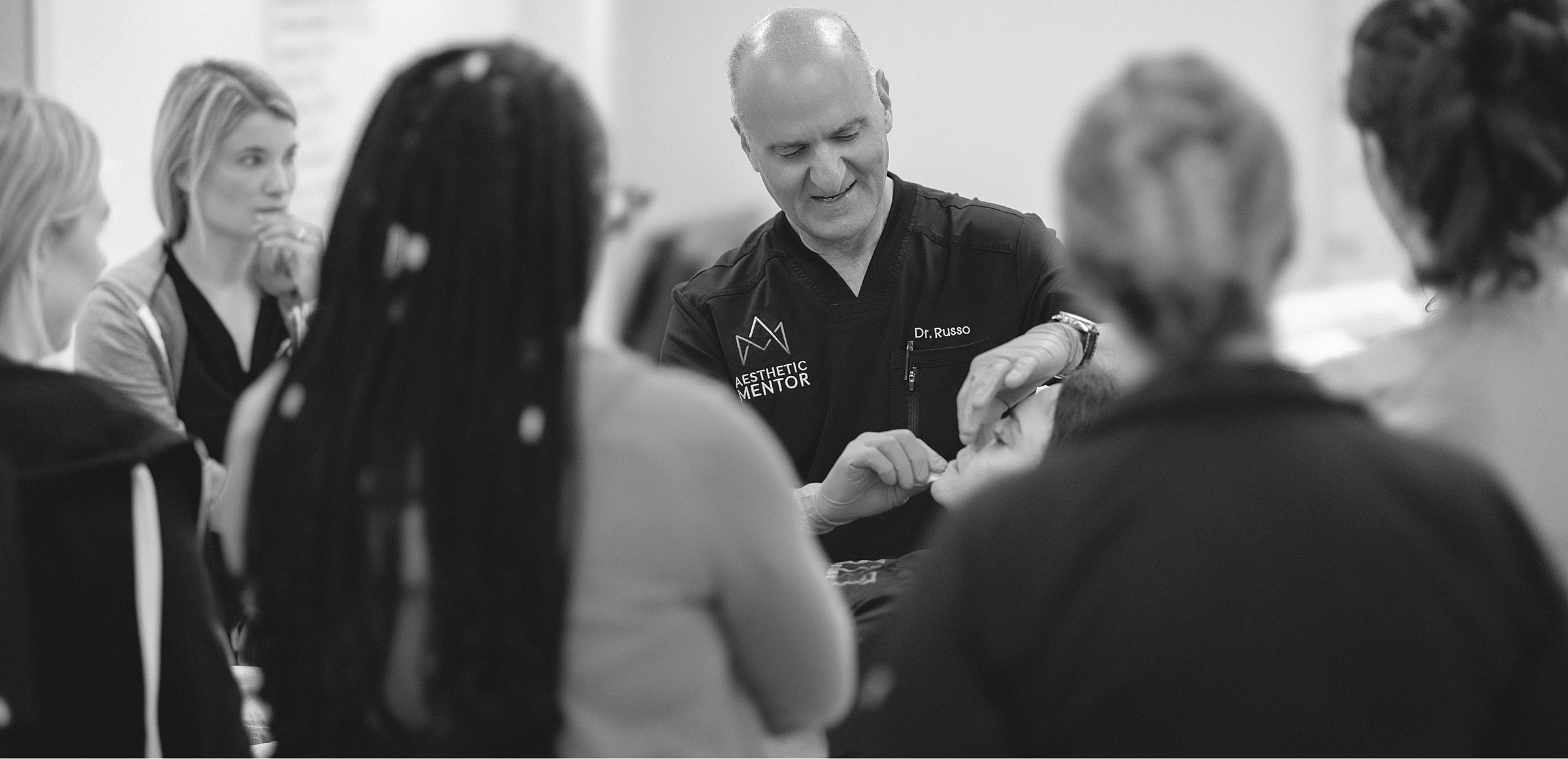 Doctor demonstrating techniques to a group of students.