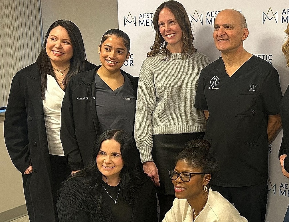 Group photo of aesthetic medical professionals smiling.